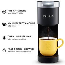 Black Keurig K-Mini single serve coffee maker pouring coffee into yellow mug
