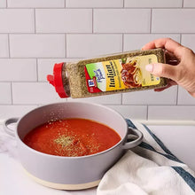 McCormick Italian seasoning bottle pouring into pot of red sauce.