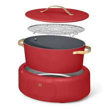 Red electric multi-cooker with lid and steamer rack accessory