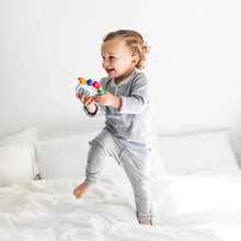 Infant holding musical take-along toy with colorful bead chaser and glowing screen
