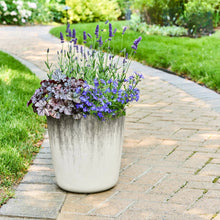 Round plastic planter, taupe speckled two-tone finish, on patio pavers
