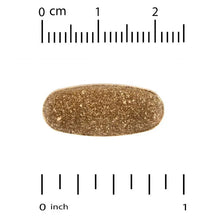 Vegetarian supplement tablet, oval brown, beside measurement markings