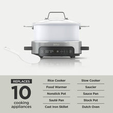 White multi-cooker with lid, front controls, and silicone spatula accessory at side