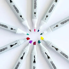 Dual-tip alcohol markers with gray barrels and white caps fanned out for use