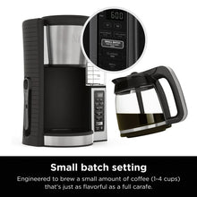 Black and stainless coffee maker with carafe and close-up of control display