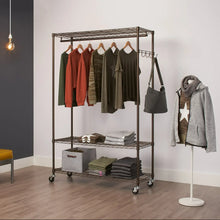 Bronze rolling garment rack with hanging hooks and wire shelves, holding folded clothes and bags