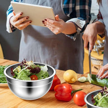Stainless steel mixing bowl on a kitchen counter with vegetables