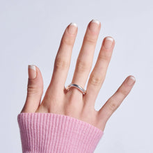 Short white French-tip press-on nails on fingers with silver ring