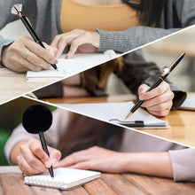 Black fancy ballpoint pen with rose-gold detailing used for writing in a notebook