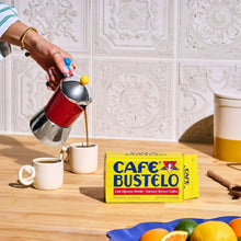 Cafe Bustelo ground coffee brick on countertop near poured coffee in a cup