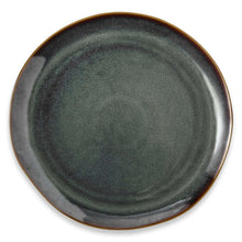 Close-up of dark teal reactive ceramic plate surface with brown-gold edge rim
