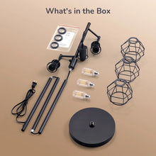 Lamp parts and caged shades laid out with bulbs, base, and metal pole pieces