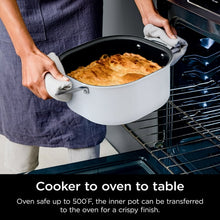 Multi-cooker with white inner pot on oven rack, hands placing the pot