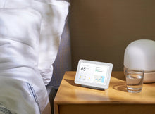 Chalk smart display on a bedside table next to a glass and lamp