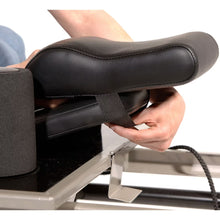 Black head and neck support pillow with adjustable fabric strap on bench