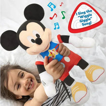 Singing Mickey Mouse plush toy being held, blue shirt and red shorts visible