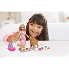 Child playing with blonde doll, brown puppy, and pet accessories on a play mat