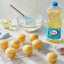 Vegetable oil bottle on kitchen counter near cupcakes cooling on a rack