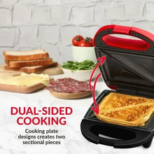 Red sandwich maker grill with lid open and grilled sandwich on the plate
