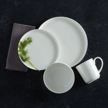 White bone china dinnerware set with large plate, side plate, and mug.