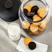 Assorted sandwich creme cookies in a clear glass jar with white and dark sandwich cookies