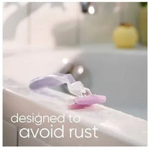 Gillette Venus razor with pink/purple handle and head resting on sink water