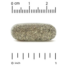 Herbal supplement tablet, gray-green, shown with size ruler