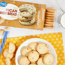 Pecan shortbread cookies stack in clear tray beside packaged cookies