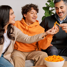 Family sharing chips snack with bowl on a couch