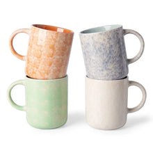 Ceramic coffee mug with orange speckled glaze, curved handle, round rim