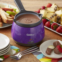 Purple candy melting pot with black handle, filled with melted chocolate