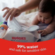 Huggies Skin Essentials wipes pack with a wipe being pulled from the lid