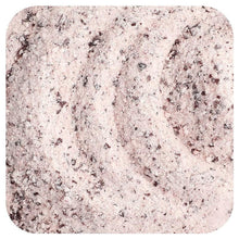Creatine powder sample in close-up, light pink with dark specks