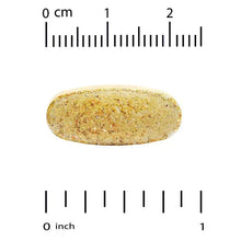 Oval multivitamin tablet with speckled surface next to measurement marks