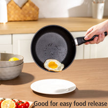 Black nonstick skillet holding a fried egg, short riveted handle