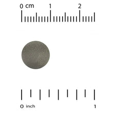 Spirulina tablet size guide with gray tablet and inch measurement scale