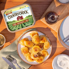 Country Crock Original family size buttery spread tub with lid on wooden surface