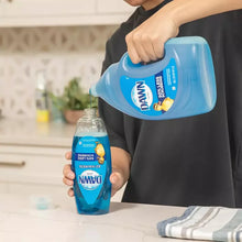 Blue dishwashing liquid bottle held by hand with a smaller bottle on counter