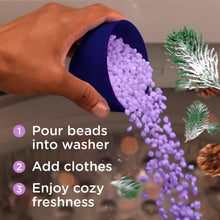 Purple laundry scent booster beads pouring from a small measuring cup