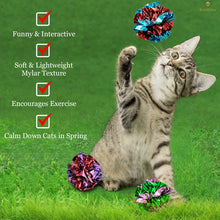Gray tabby cat sitting with multicolor mylar crinkle balls on the floor