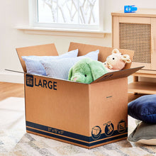 Large kraft moving box filled with bedding and a plush toy