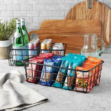 Two-tier fruit basket stand with black wire baskets and bamboo handle, filled with packaged goods