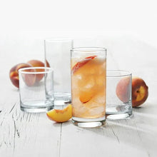 Clear tumblers with fruit-filled drinks and slices, set of assorted sizes on tabletop.