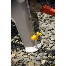 Gray plastic step stool leg with yellow grip foot on rocky ground