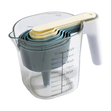 Clear measuring pitcher with nested blue stackable cups and measurement scale