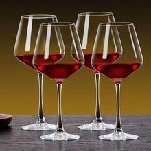 Set of red wine glasses, clear stems with burgundy wine, four glasses on table