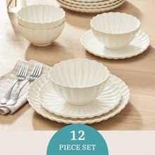 Cream scalloped stoneware bowls and plates, 12-piece set on table