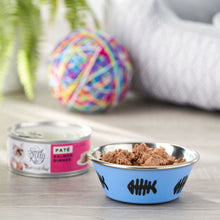 Wet cat food pate can with bowl of brown pate and colorful toy nearby