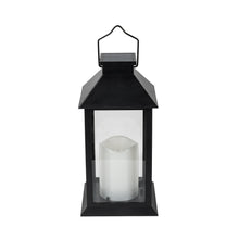 Black solar lantern with glass panels and handle, frosted candle cylinder visible inside.