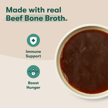 Bowl of dark brown broth-style dog kibble sauce with white rim